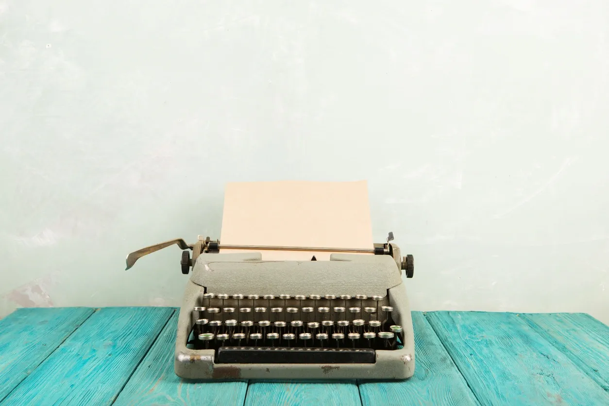 Vintage typewriter on a turquoise wooden table.